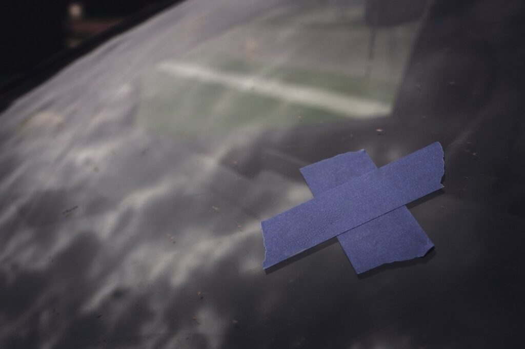 Tape covering a chip on a car windshield